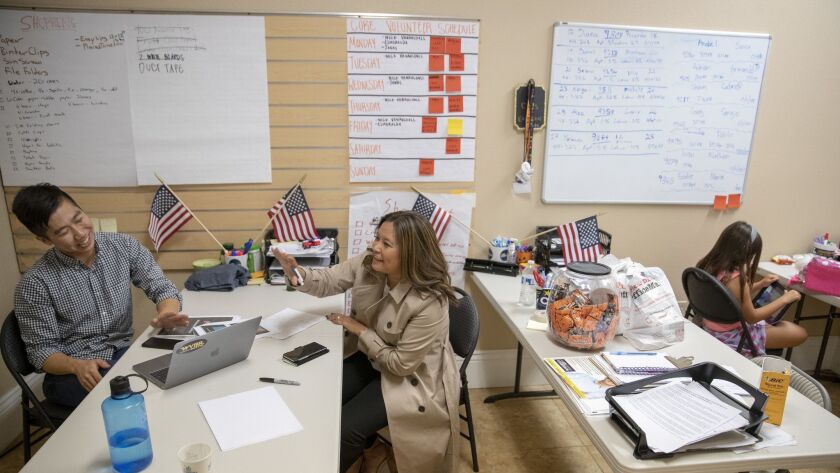Katie Kalvoda talks to deputy political director Allen Chen at Gil Cisneros' campaign office as her daughter, 8, settles in with an iPad. A former investment banker who was previously apolitical, she is putting her professional skills to politics ahead of the midterm elections.