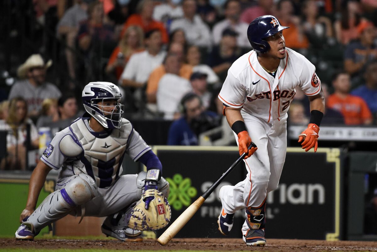 Houston Astros' Michael Brantley, right, hits an RBI double during the fifth inning of a baseball game against the Colorado Rockies, Tuesday, Aug. 10, 2021, in Houston. (AP Photo/Eric Christian Smith)