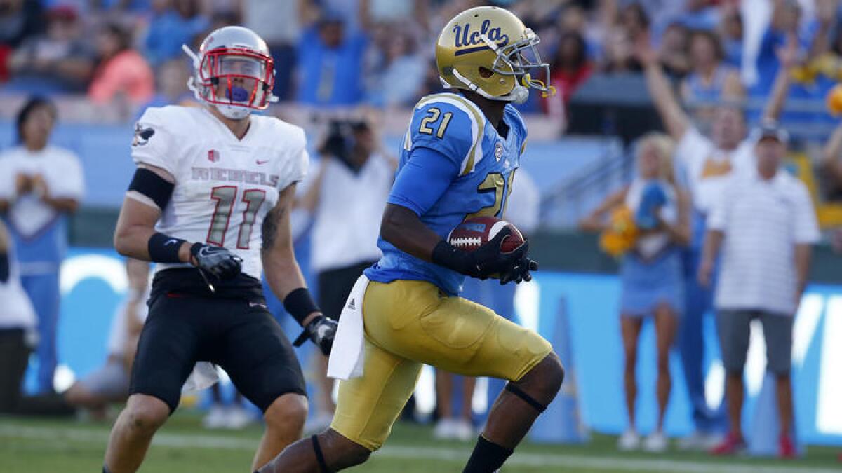 UCLA wide receiver Mossi Johnson beats UNLV defensive back Troy Hawthorne into the end zone in the second quarter.