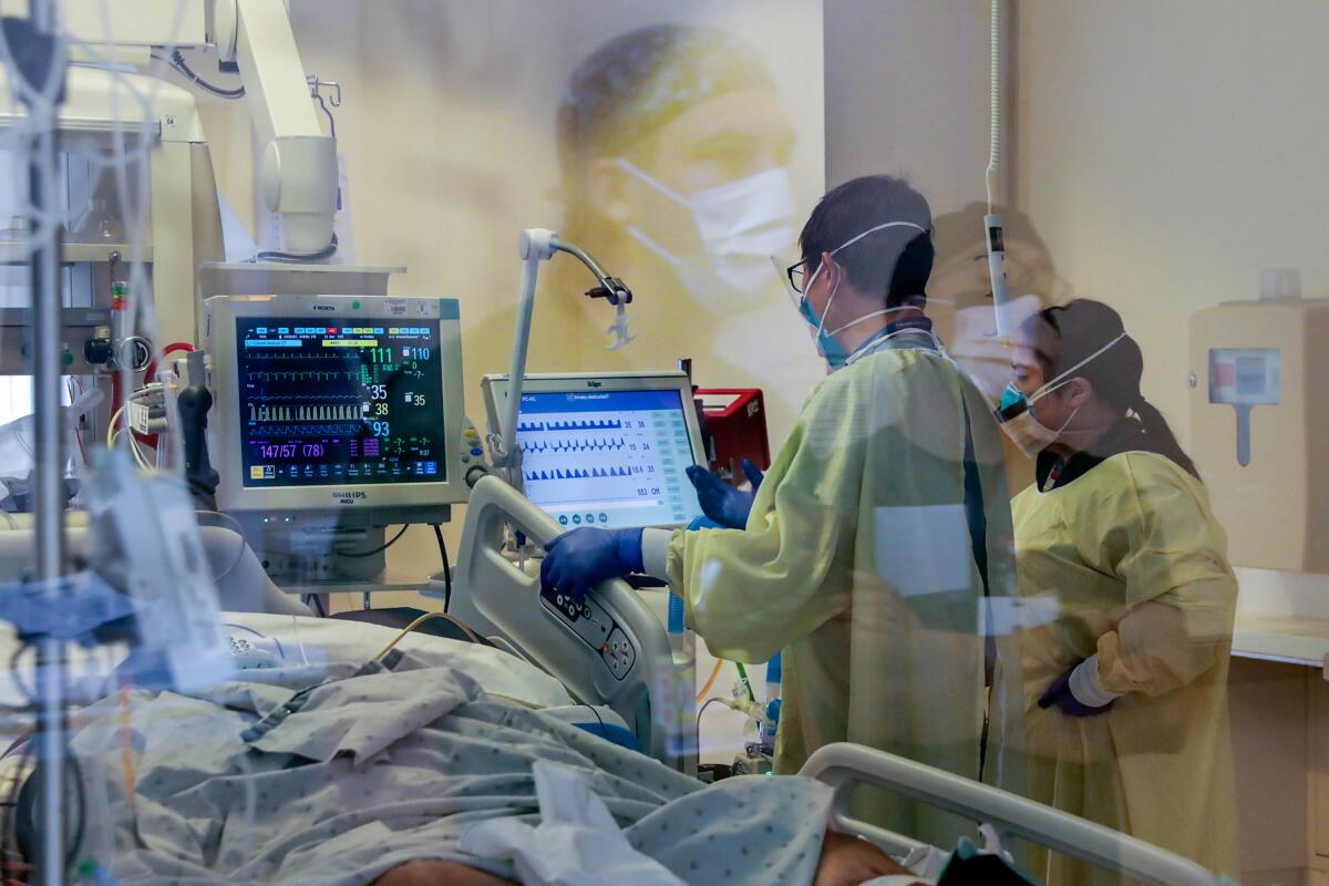 Doctors check the vitals of a COVID patient in the intensive care unit.
