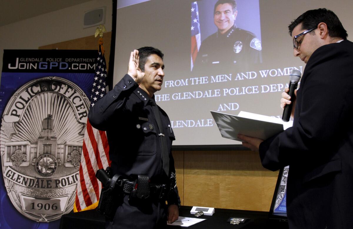 Glendale city clerk Ardashes Kassakhian, right, swears in the new Glendale Police chief Robert Castro, left, during a swearing in ceremony at the Glendale Police Dept. headquarters in Glendale on Thursday, Dec. 19, 2013.