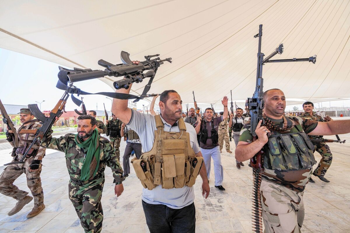 Iraqi Shiite volunteer fighters chant slogans against Sunni insurgents during a training session in Karbala.