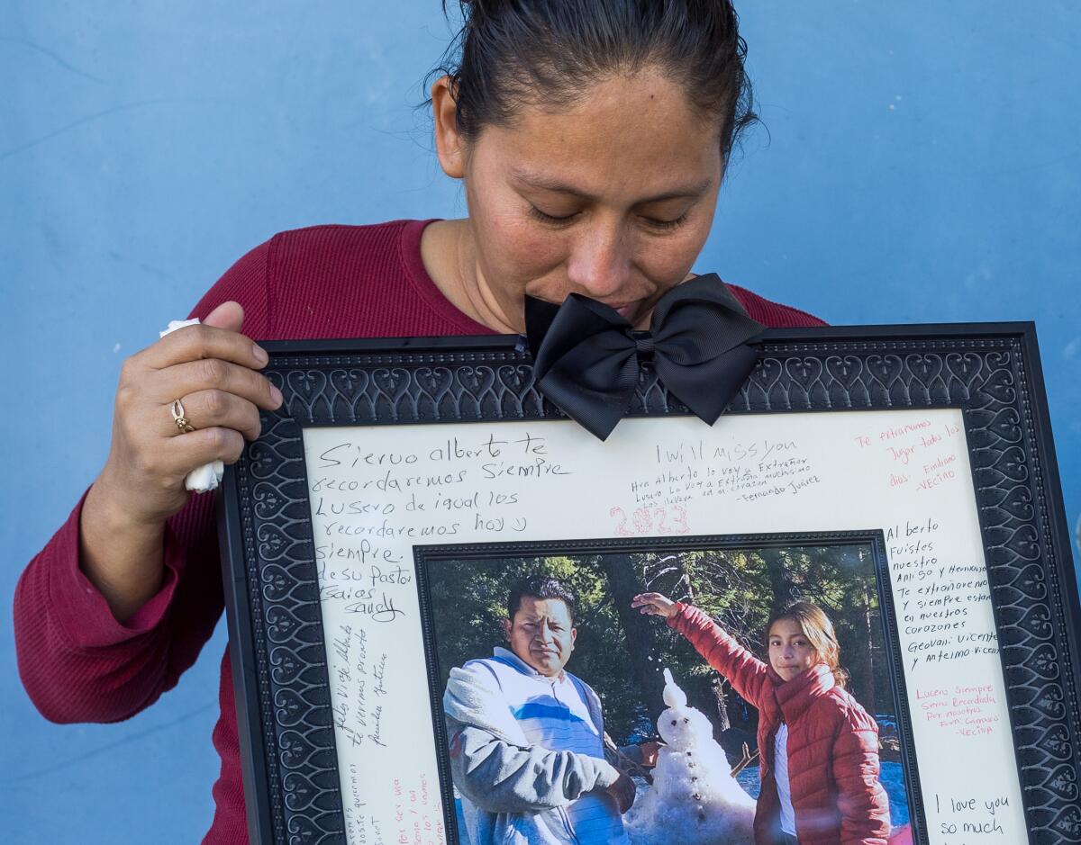Erika Lopez holds a photo of her late husband, Alberto Lopez, and daughter, Lucero