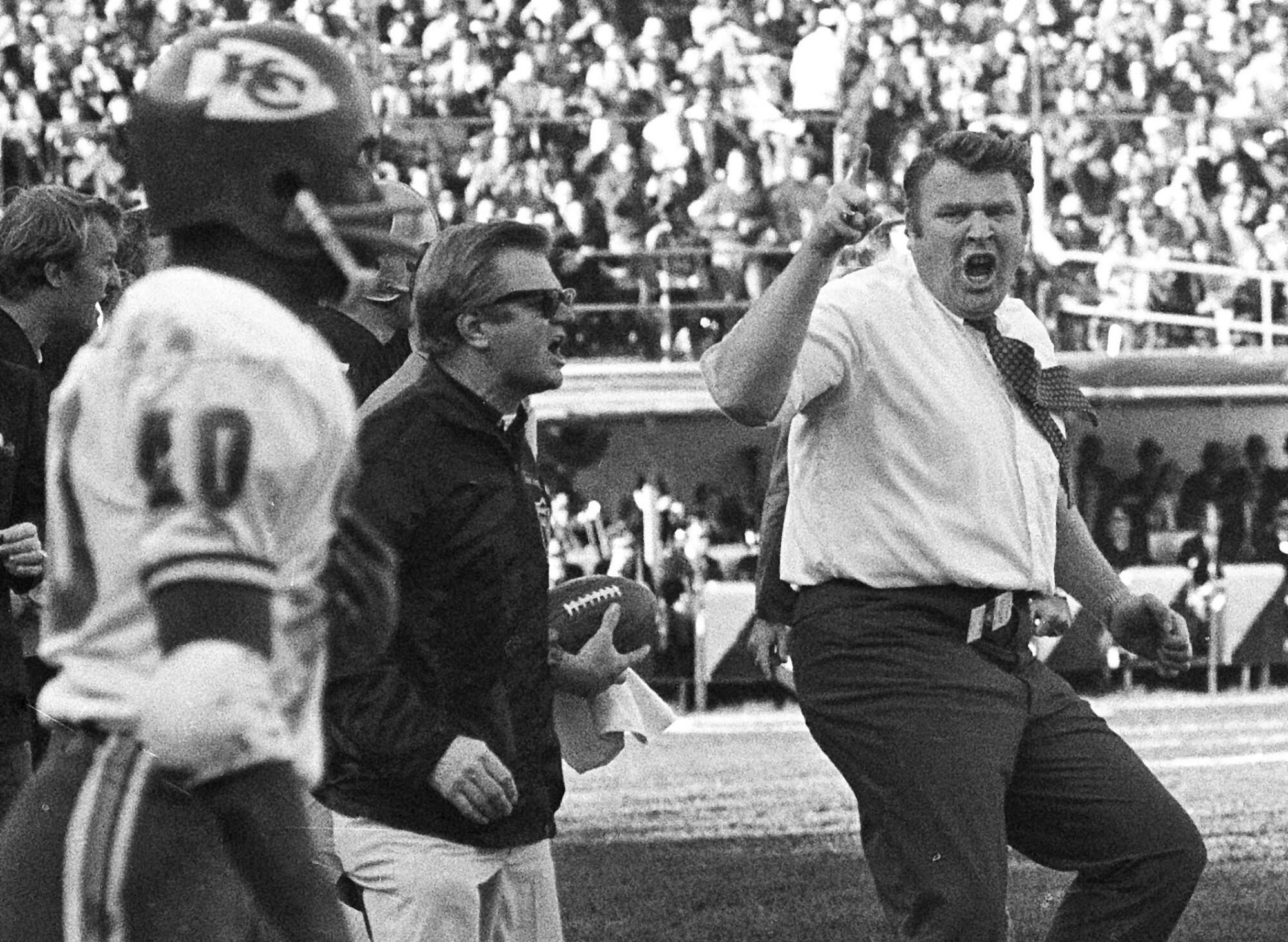 Oakland Raiders coach John Madden does a sort of jig as he waves his finger and shouts in protest at a referee's call.
