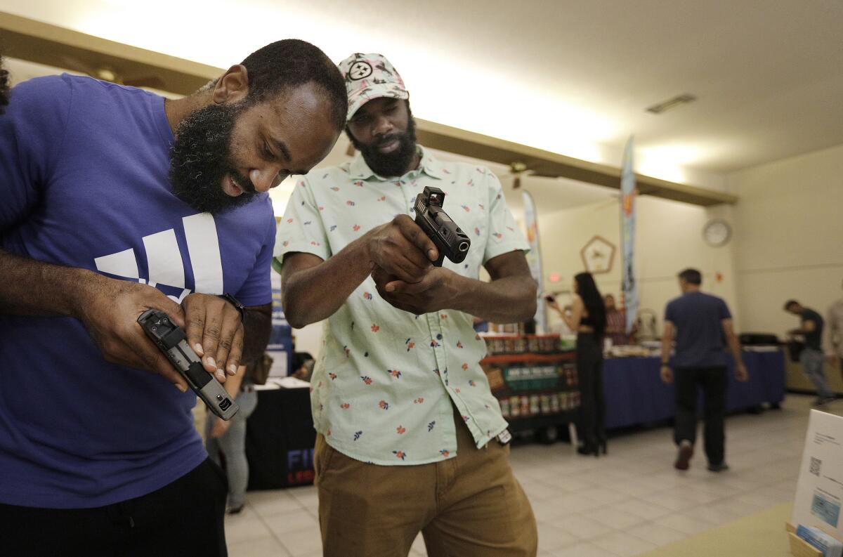 Two men look at guns at a San Diego Gun Show.
