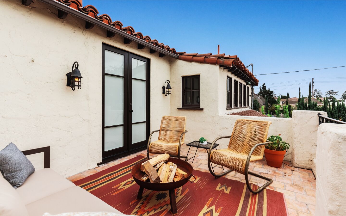The balcony with chairs and a rug and couch.