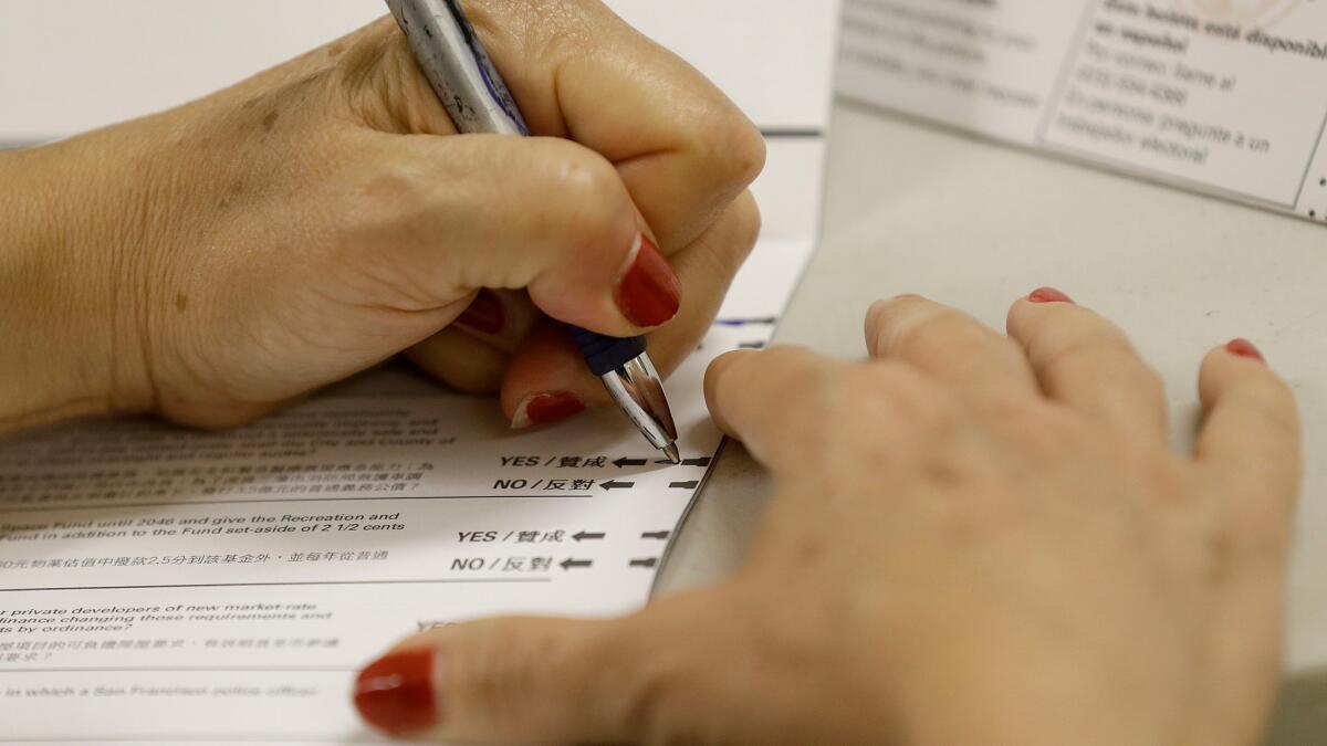 A woman fills out a ballot at City Hall in San Francisco on Tuesday, June 7.