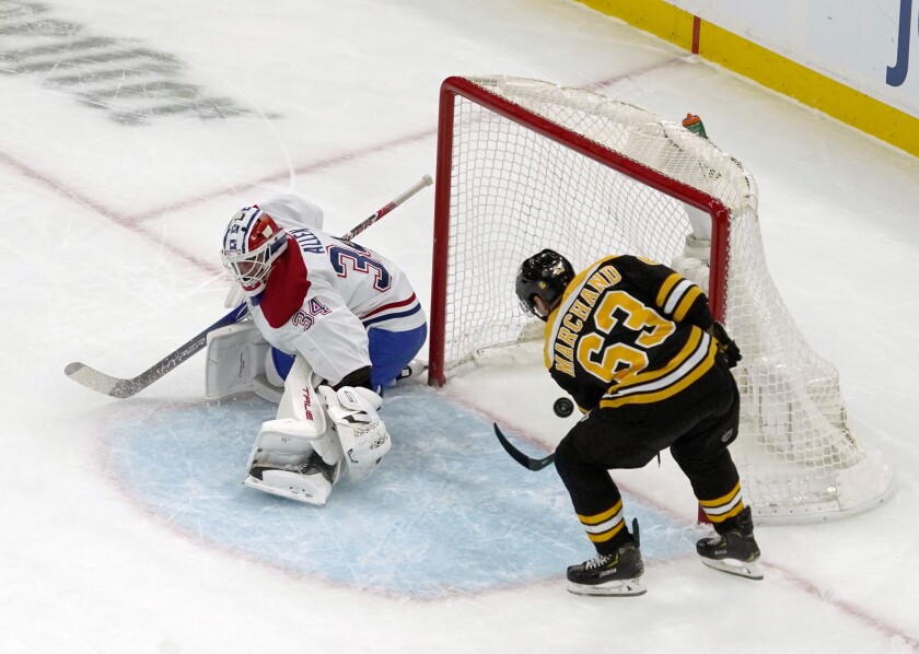 Boston Bruins left wing Brad Marchand (63) scores a goal past Montreal Canadiens goaltender Jake Allen (34) during the first period of an NHL hockey game, Wednesday, Jan. 12, 2022, in Boston. (AP Photo/Mary Schwalm)