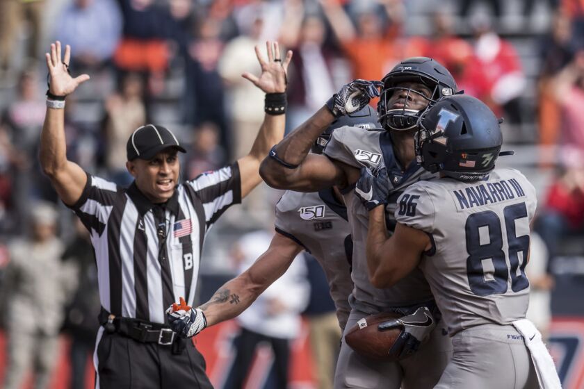 Illinois Josh Imatorbhebhe, second from right, celebrates with teammates including Donny Navarro (86) after scoring a touchdown in the second half of an NCAA college football game against Wisconsin, Saturday, Oct.19, 2019, in Champaign, Ill. (AP Photo/Holly Hart)