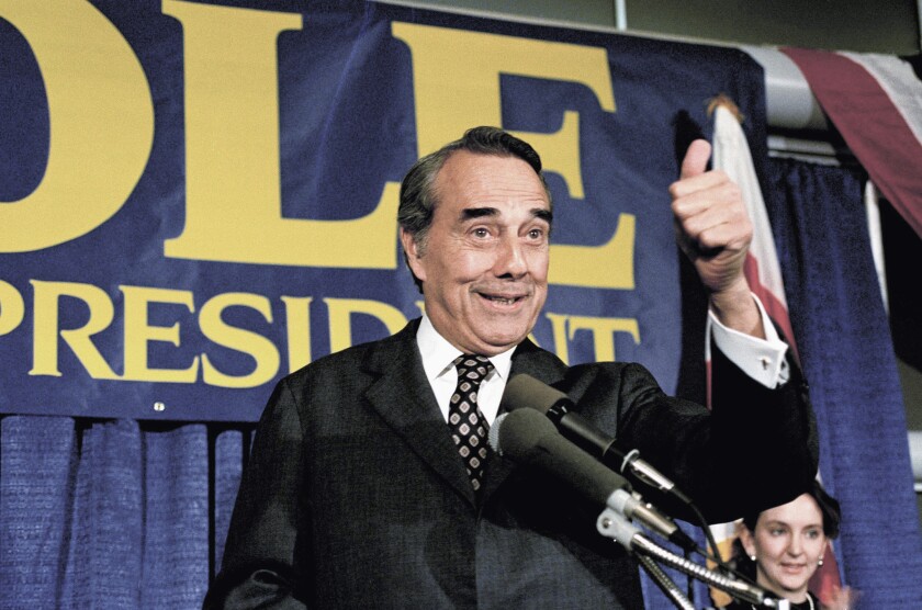 FILE - Republican presidential candidate Sen. Robert Dole R-Kan., gestures while making a speech in Washington, March 28, 1988. Bob Dole, who overcame disabling war wounds to become a sharp-tongued Senate leader from Kansas, a Republican presidential candidate and then a symbol and celebrant of his dwindling generation of World War II veterans, has died. He was 98. His wife, Elizabeth Dole, posted the announcement Sunday, Dec. 5, 2021, on Twitter. (AP Photo/Ron Edmonds, File)