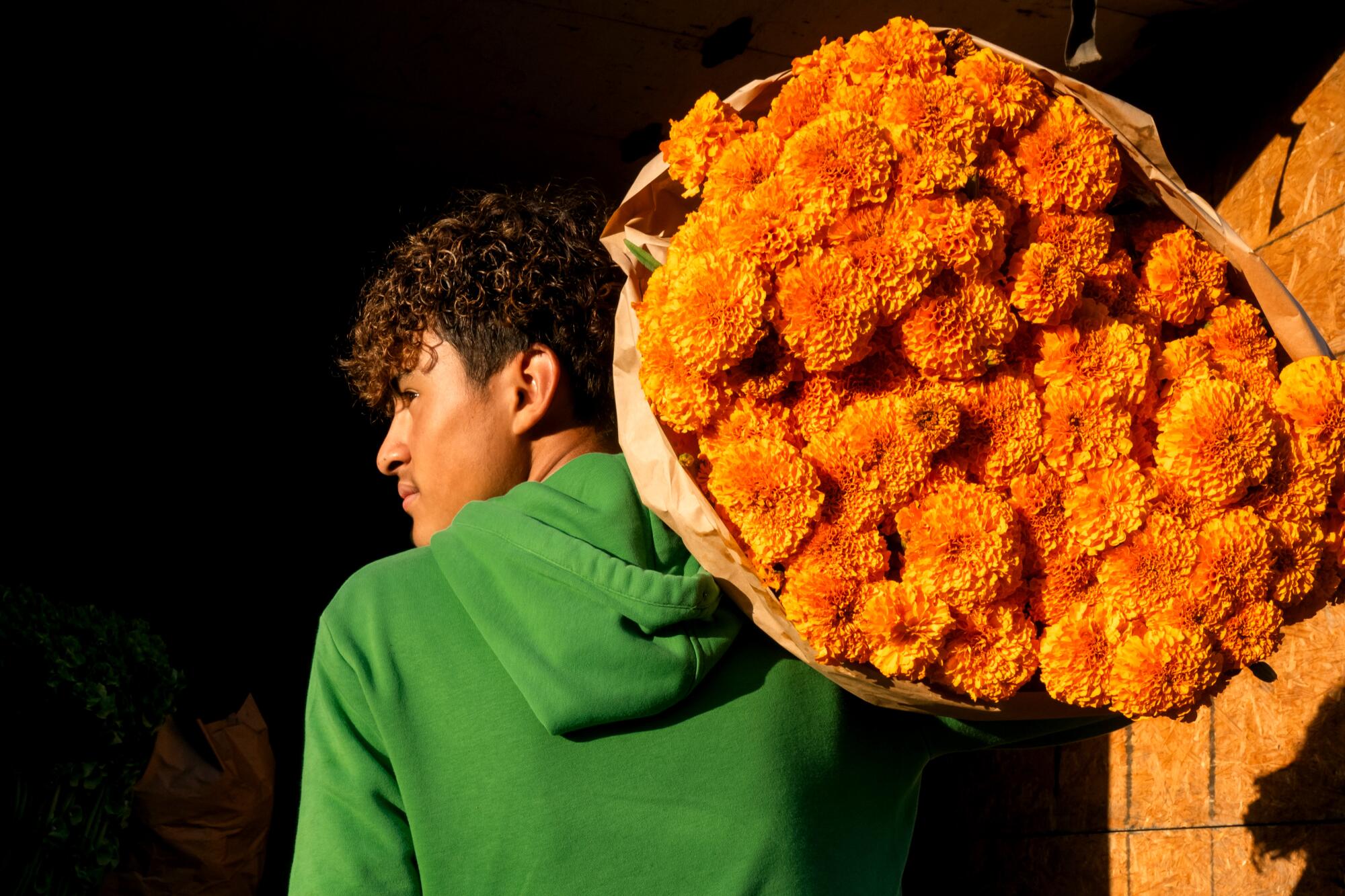Flower market worker, Angel Soteloa, unloading a fresh cempasuchil (Marigolds) truckload in downtrown L.A.