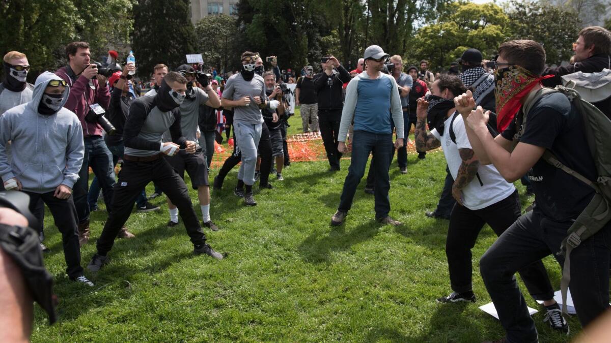 Supporters of President Trump clash with protesters at a rally at Civic Center Park organized by the Trump supporters.