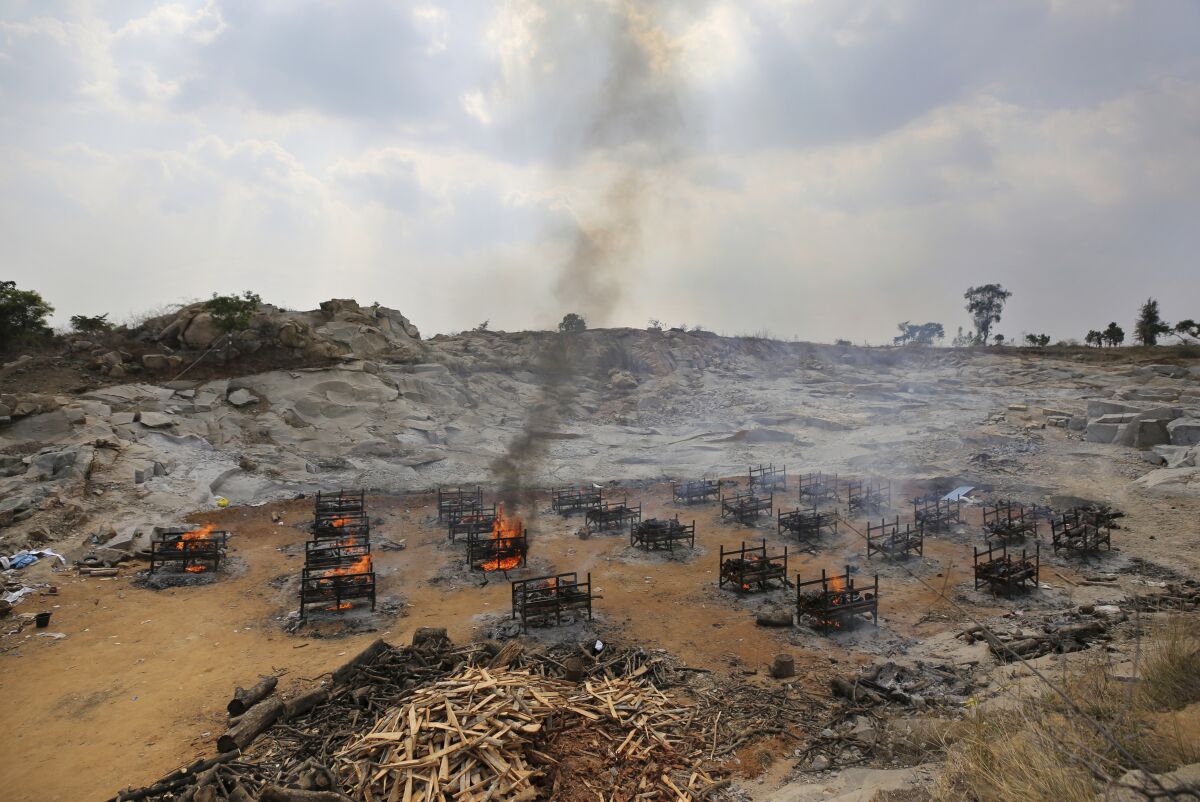 Funeral pyres of twenty-five COVID-19 victims burn at an open crematorium set up at a granite quarry on the outskirts of Bengaluru, India, Wednesday, May 5, 2021. (AP Photo/Aijaz Rahi)