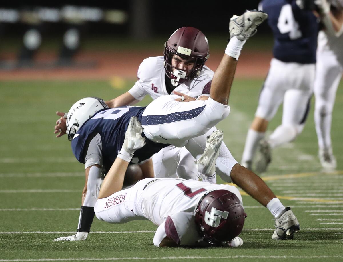 Laguna Beach defender Wyatt Degner (7) trips up Northwood running back Jace Lin on Friday at Irvine High.