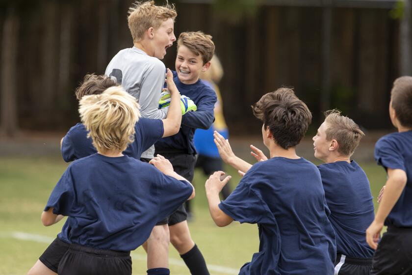 Newport Beach Mariners' goal keeper Gavin Guy jumps into the arms of his teamates after beating Corona del Mar Lincoln in penalty kicks during a boysÕ fifth- and sixth-grade Gold Division quarterfinal match at the Daily Pilot Cup on Saturday, June 1.