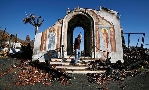 Brother Nicholas Radelmiller examines the burned remains of Mt. Calvary Monastery on Thursday. The monastery, established in 1947, was destroyed Nov. 13 when the Tea fire swept through, driven by 70 mph winds. The retreat sits on a ridge 1,250 feet above Santa Barbara, with a view of the Santa Barbara coastline and the Channel Islands.