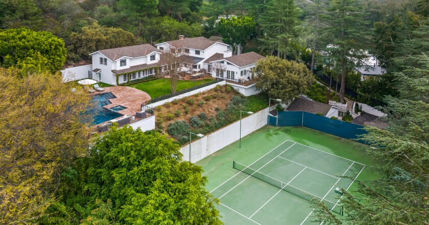 The 1.5-acre spread includes a swimming pool, tennis court and L-shaped home built in the 1970s.