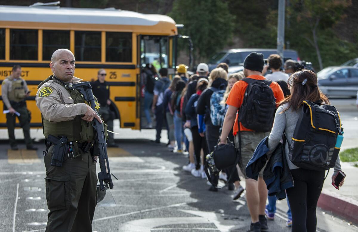 Students evacuated from Saugus High School board buses to be taken to a reunification area after the shooting in Santa Clarita, Calif.