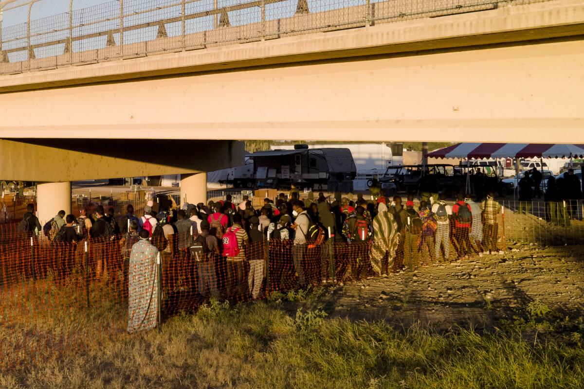 Migrantes detenidos hacen fila para subir a autobuses debajo del Puente Internacional de Del Rio, en Del Rio, Texas. 