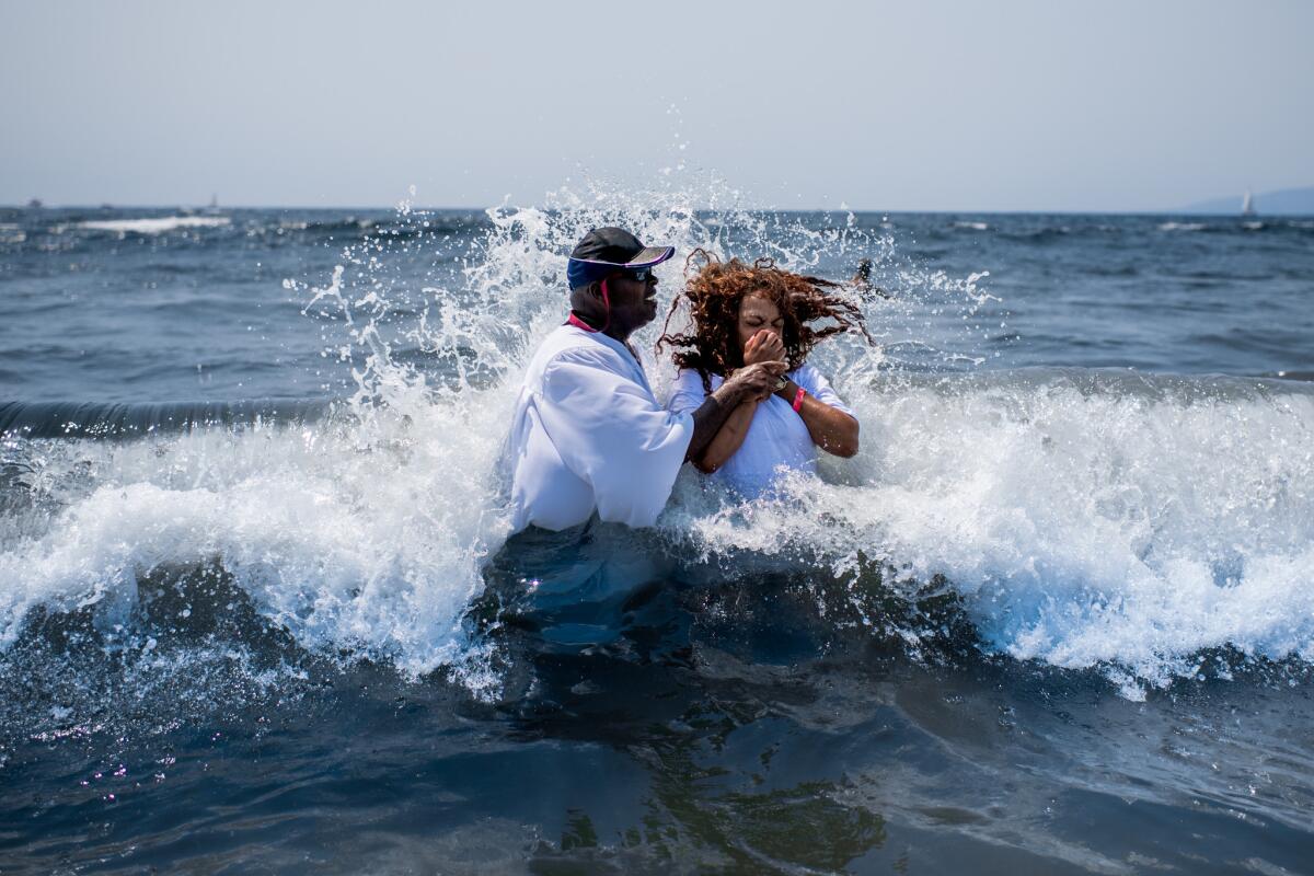 Bishop John Moore baptizes a woman during the rally in Venice.