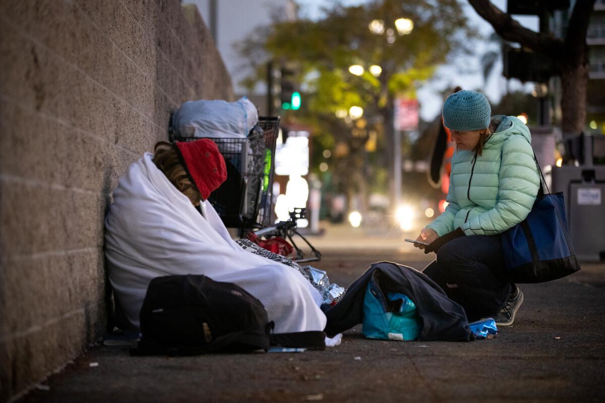 Amy Denhart, a volunteer, speaks to a man experiencing homelessness during the annual point-in-time in downtown. 