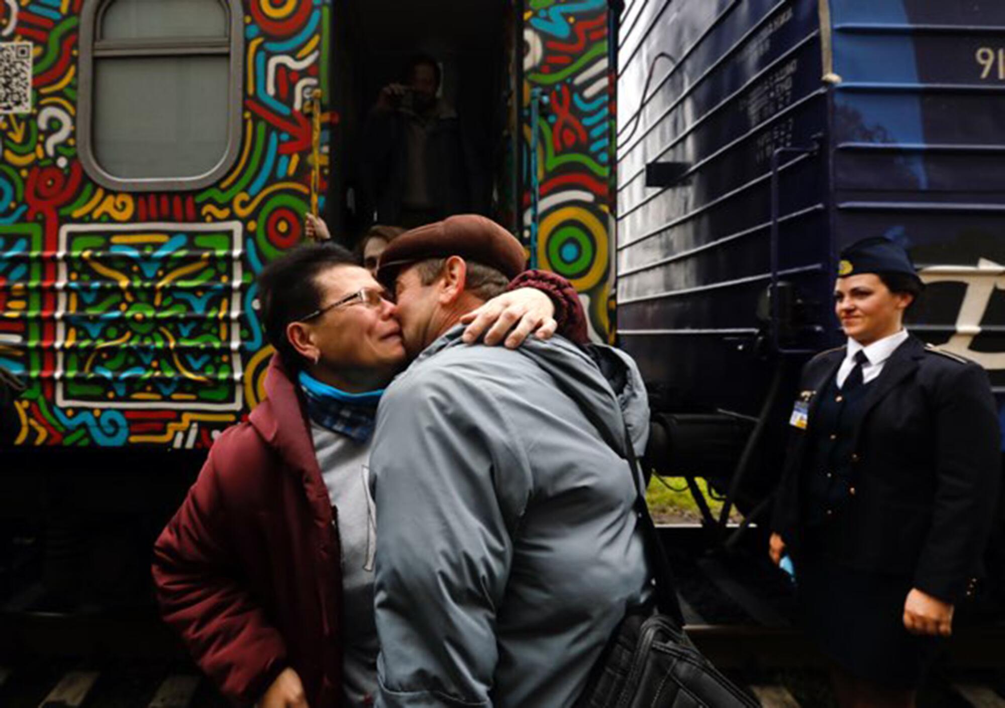 Man greets wife with a hug and single rose.