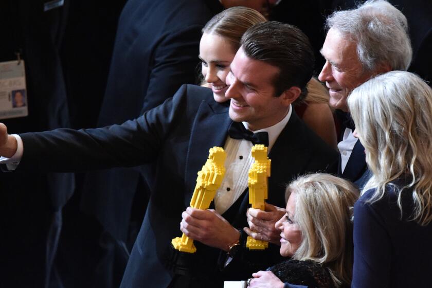 Model Suki Waterhouse, left, actor Bradley Cooper and director Clint Eastwood pause for a selfie with Oscars made of Legos at the Academy Awards in February.