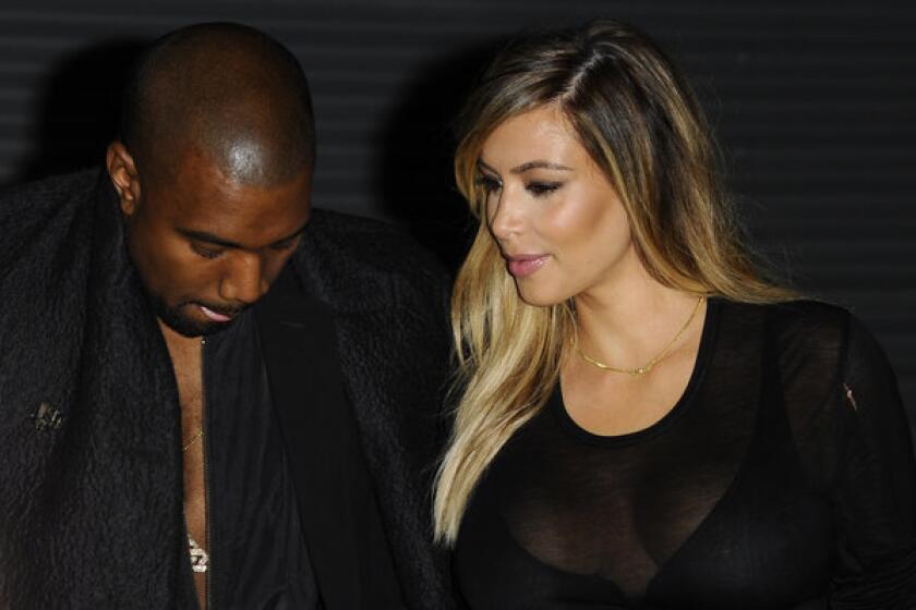 Kanye West, left, and Kim Kardashian, at Givenchy's ready-to-wear fashion show last month in Paris, sometimes use clothes to stay close.