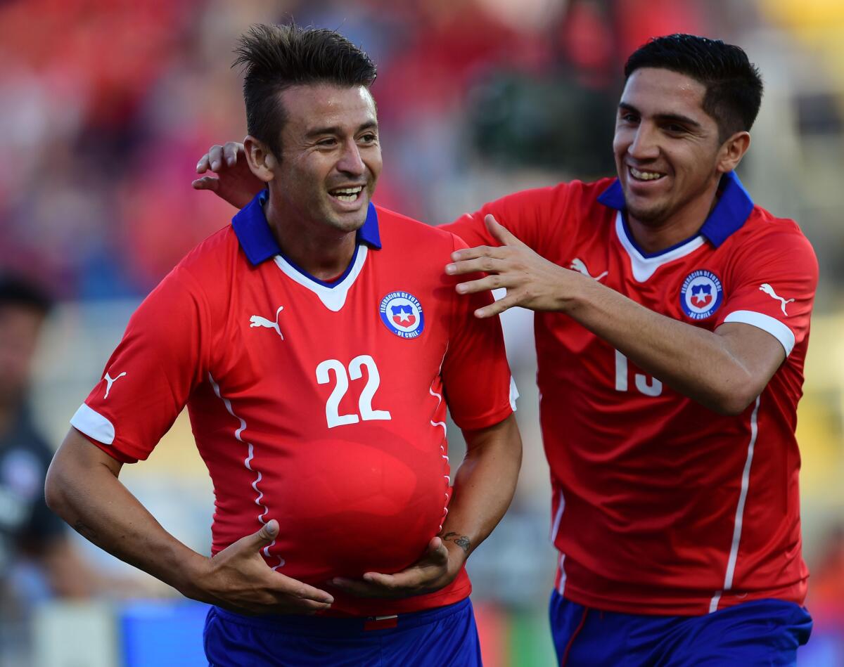 Roberto Gutierrez of Chile celebrates with teammate Diego Valdez, right, after scoring a goal against the U.S. national team during a friendly match at El Teniente Stadium in Rancagua, Chile.