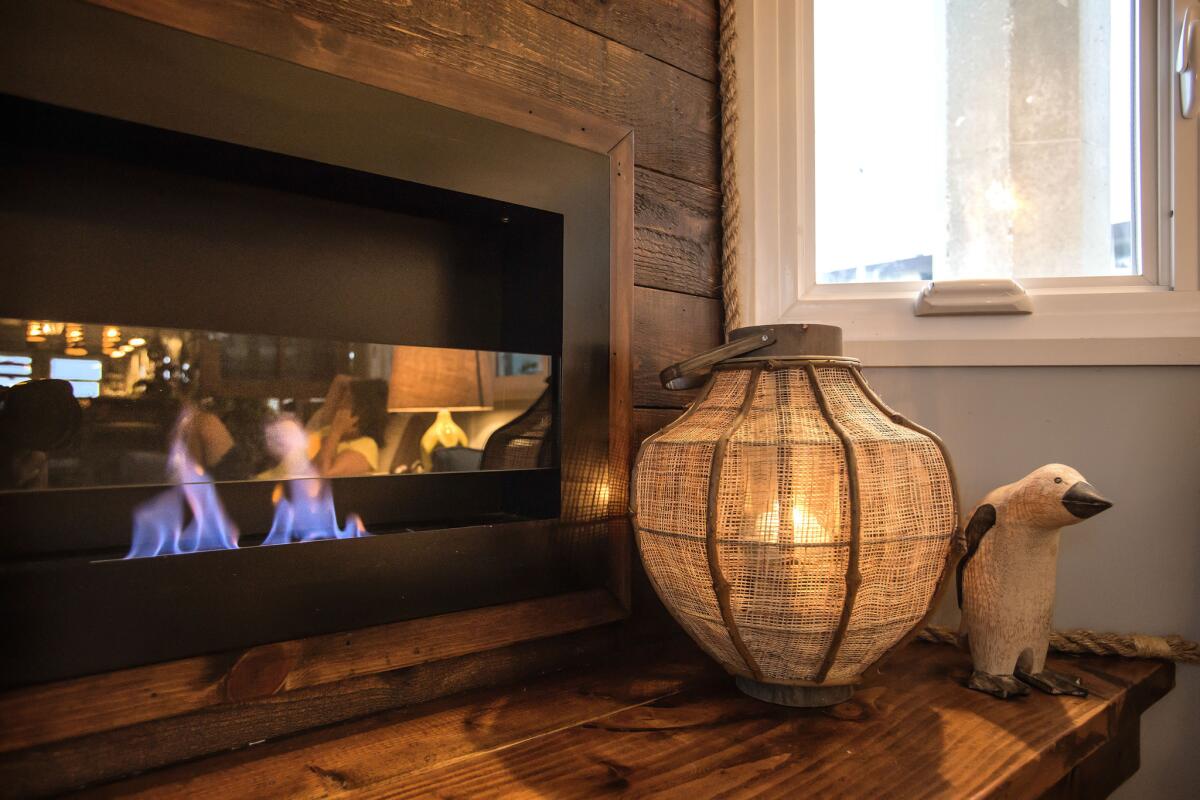 Detail of the ventless alcohol-burning fireplace, where a platform provides a place to sit and to display decorative accents, as well as creates a natural spot for storage bins below. Owner Misty Tosh trimmed the gap between the fireplace and walls with marine sisal. "When in doubt," she said, "wrap it in rope."