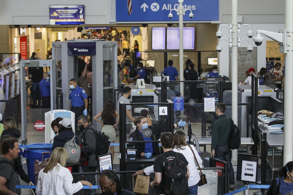 Passengers go through a TSA security checkpoint at an airport.