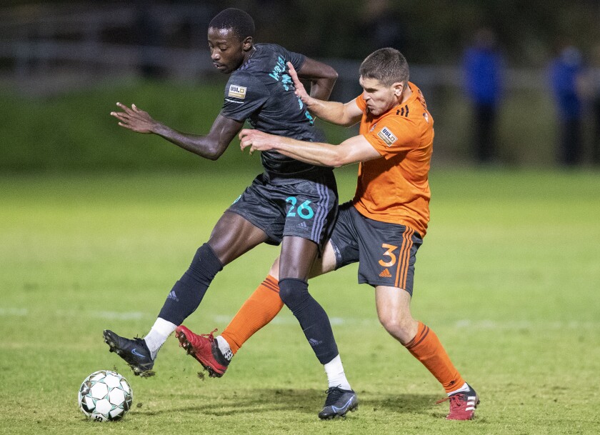 Orange County Soccer Club's Dillon Powers battles for a ball against the San Diego Loyal's Augustine Williams.