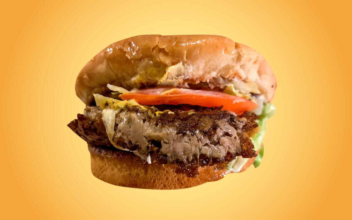 Closeup of a meaty, messy hamburger.