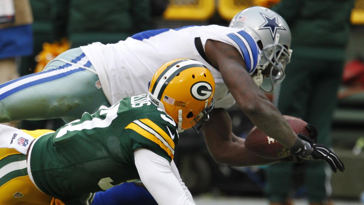Dallas Cowboys wide receiver Dez Bryant hauls in a pass over Green Bay Packers cornerback Sam Shields during the fourth quarter of the Packers' playoff win Sunday. An initial call of a completed catch was reversed on replay.