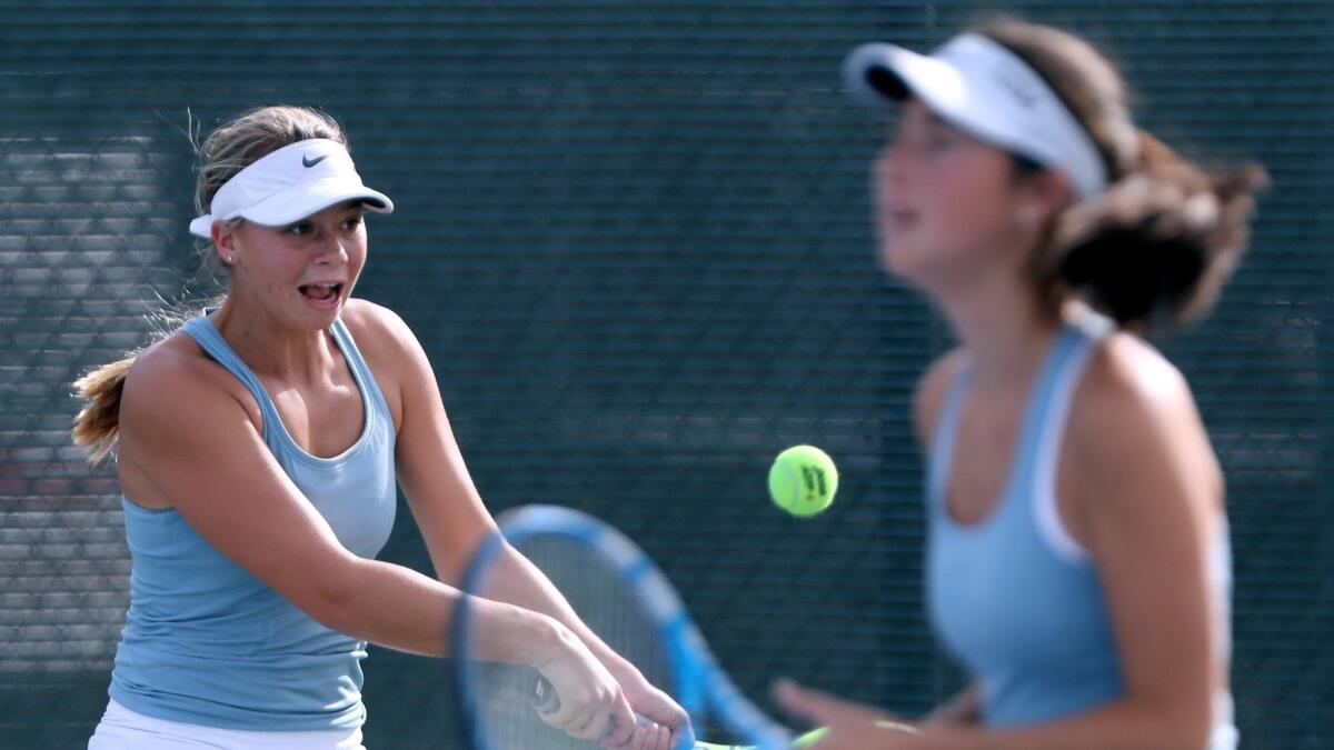Corona del Mar High's Reece Kenerson returns the ball as doubles partner Hannah Jervis looks on in the CIF Southern Section Individuals tournament round of 32 match at Whittier Narrows Tennis Center in South El Monte on Tuesday.