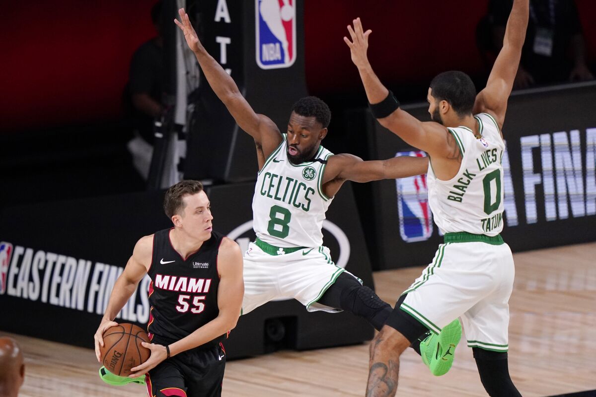 Miami Heat's Duncan Robinson (55) looks for help as Boston Celtics' Kemba Walker (8) and teammate Jayson Tatum (0) defend during the second half of an NBA conference final playoff basketball game Sunday, Sept. 27, 2020, in Lake Buena Vista, Fla. (AP Photo/Mark J. Terrill)