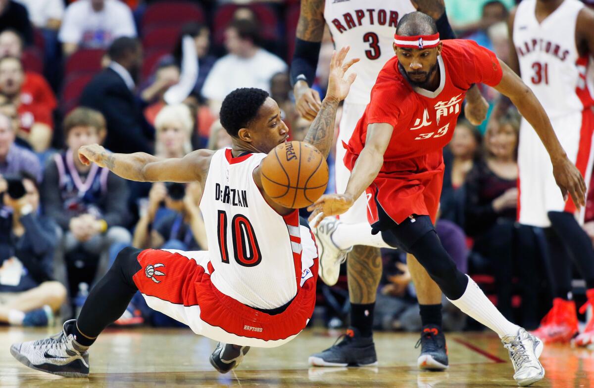 Houston's Corey Brewer, right, chases a loose ball around Toronto's DeMar DeRozan on Saturday night.