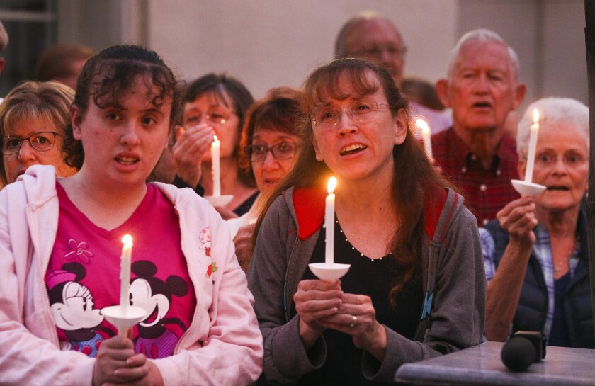 Linda Borders, center, her daughter Laurie Borders, left, and people from the community, many of them of various faiths, join members of the Rancho Bernardo Community Presbyterian Church to sing during a candlelight vigil for the Chabad of Poway synagogue shooting victims at the Rancho Bernardo Community Presbyterian Church in Rancho Bernardo on Saturday, April 27, 2019 in San Diego, California.