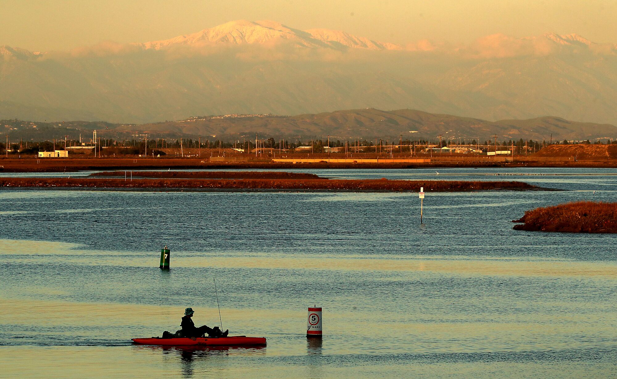 A light dusting of snow covers Mount Baldy, seen from Sunset Beach on Tuesday.