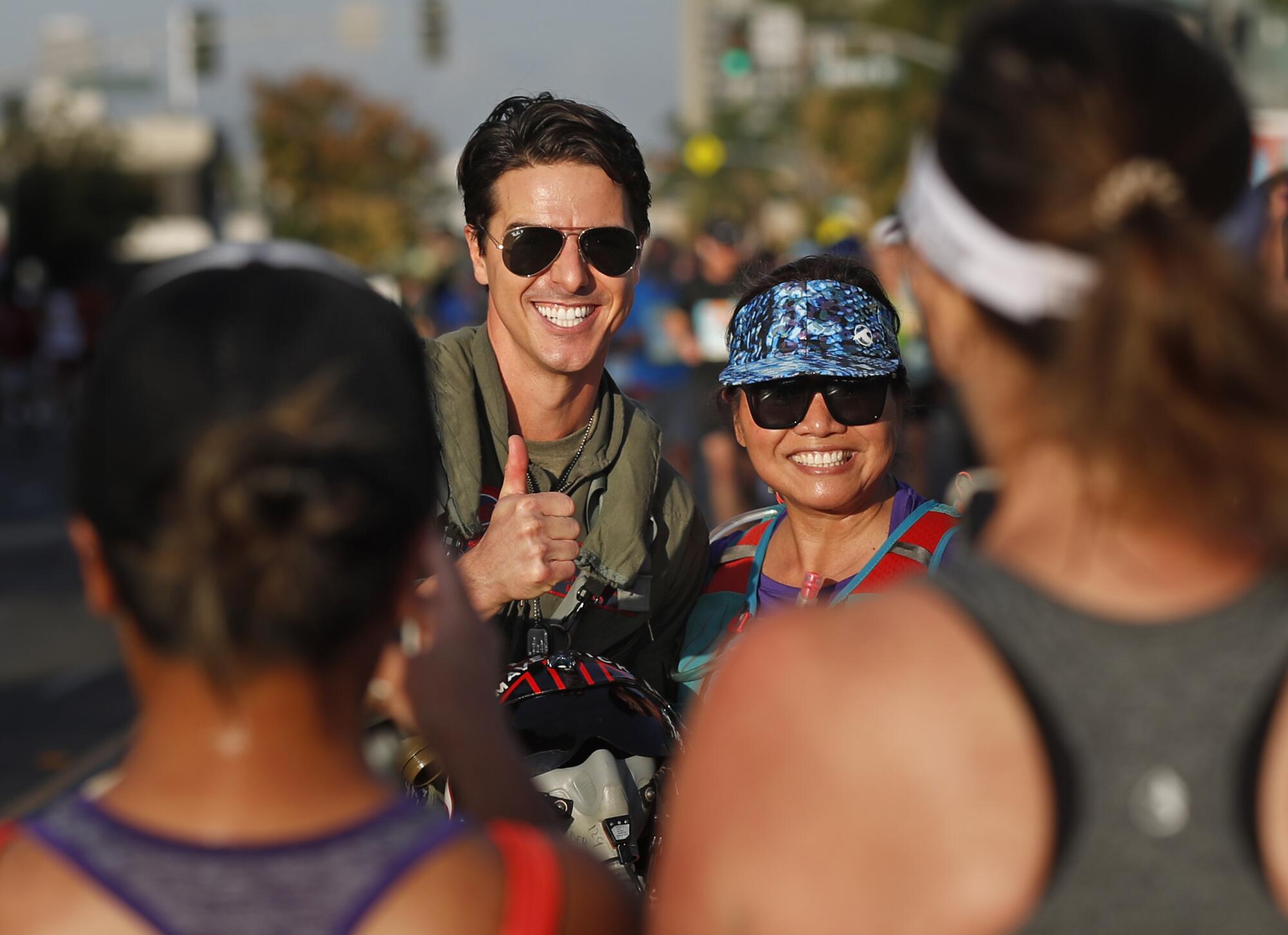 Jerome LeBlanc, dressed as Tom Cruise's character Maverick from Top Gun, entertains runners in North Park