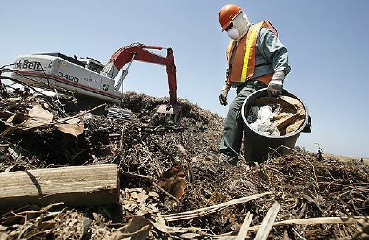 A worker picks trash out of construction rubble at the former El Toro Marine base. The rubble will be pulverized, mixed with green waste, and recycled into products such as mulch and topsoil.