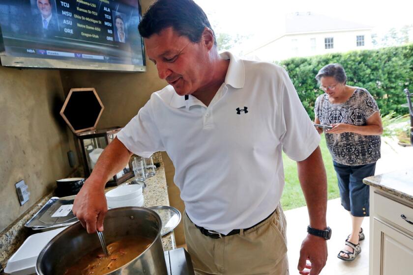 Ed Orgeron stirs the gumbo pot at his home in Mandeville, La., where the former USC assistant and interim coach spoke of a possible return to USC.