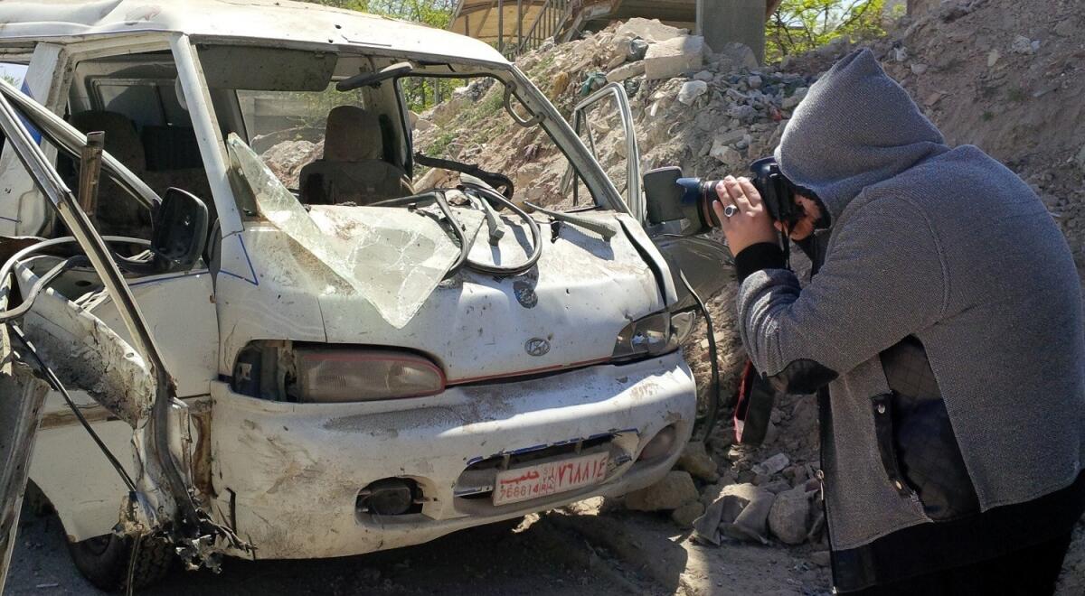 Saleh Laila, a media activist with the rebel Al Tawheed Brigade and a stringer for the Turkish Anatolia news agency, photographs the site of a deadly barrel bomb attack in the Syrian city of Aleppo.