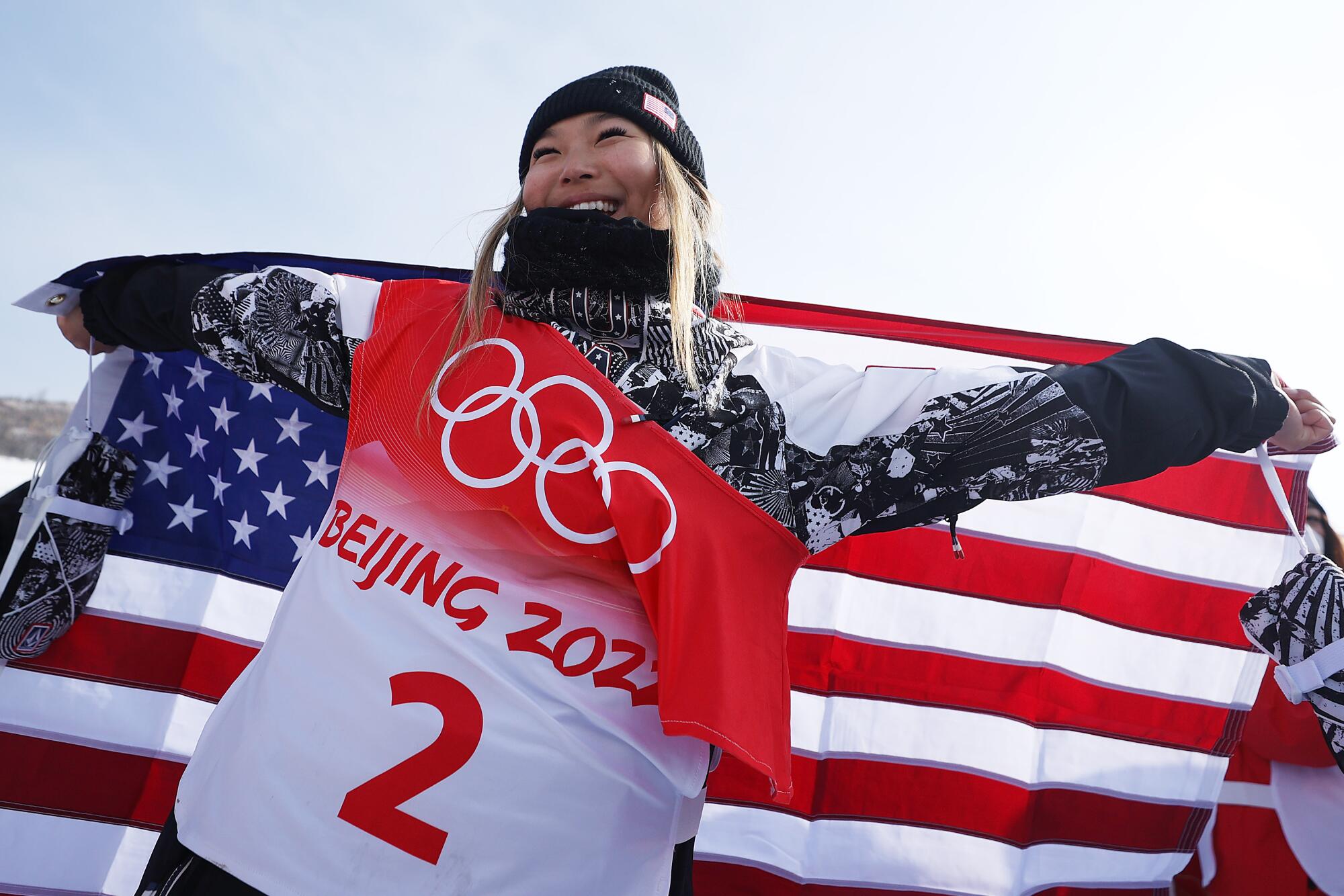 Chloe Kim celebrates with an American flag after winning the gold medal at the Olympics.