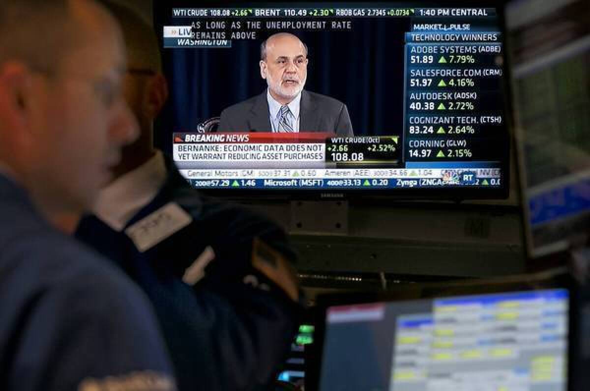 Federal Reserve Chairman Ben S. Bernanke's televised news conference Wednesday is shown at the New York Stock Exchange. He defended the Fed's surprise move.