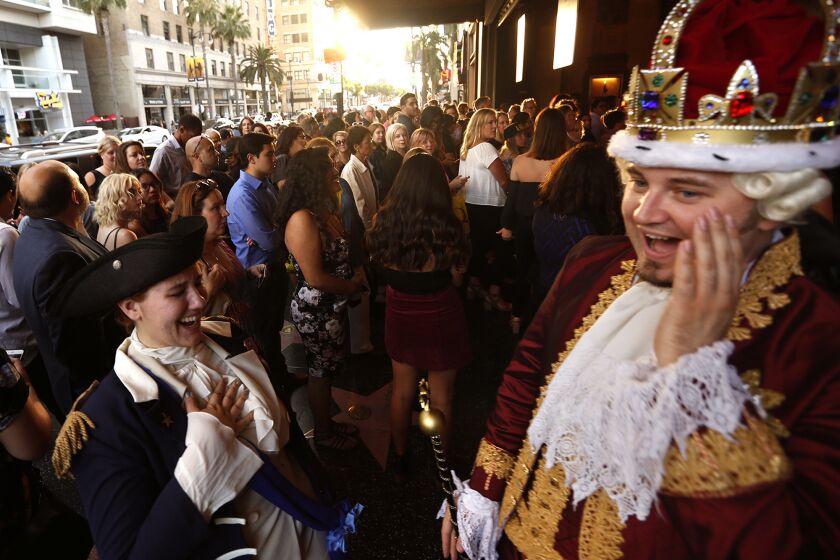 Chad Evett as King George III and Katie Aiani as George Washington enjoy a light moment as people wait for the Pantages Theatre to open its doors for the preview performance of "Hamilton" in Hollywood on Friday.