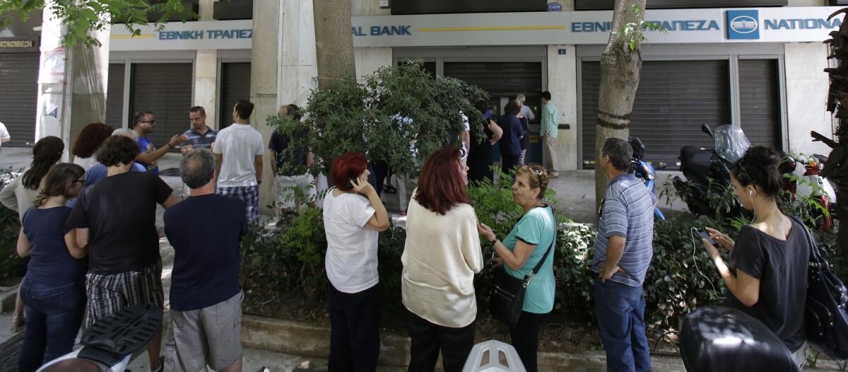 Decenas de personas hacen fila ffrente a un cajero automático en el centro de Atenas, el domingo 28 de junio de 2015. (Foto AP/Thanassis Stavrakis)