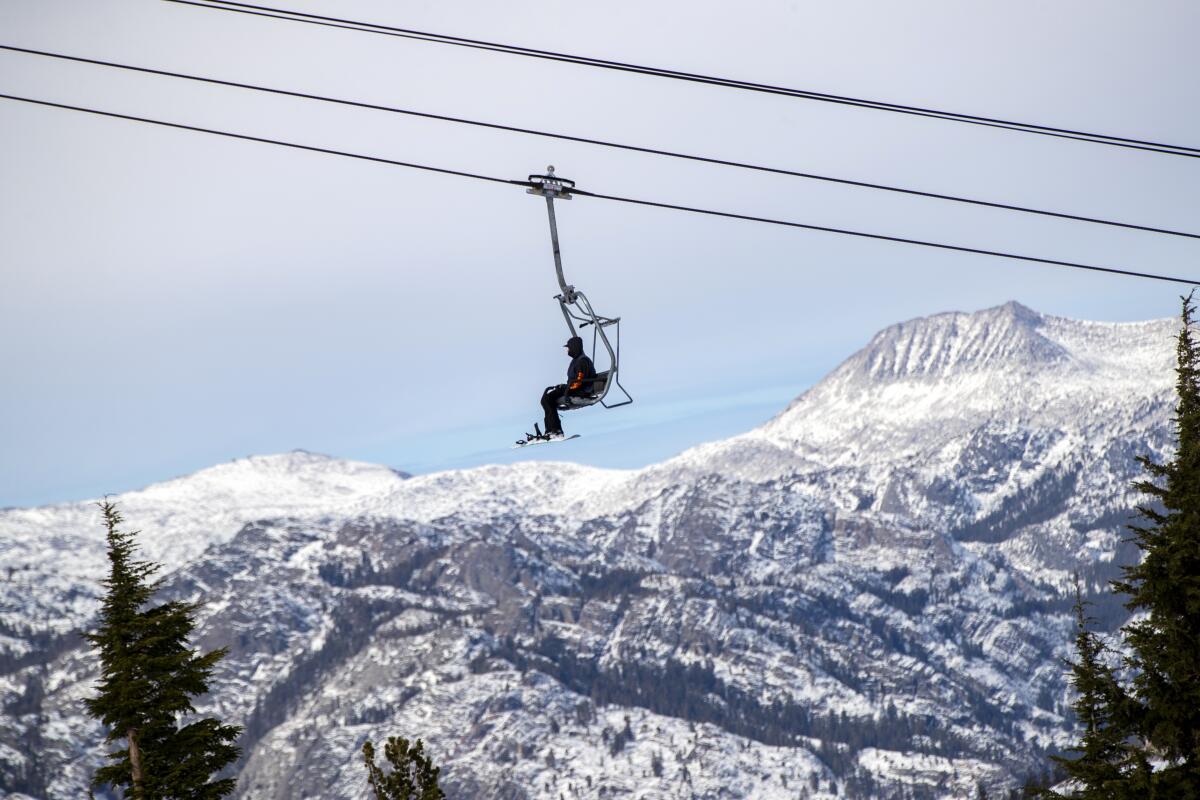 A snowboarder rides a chair lift at Mammoth Mountain in November 2020.