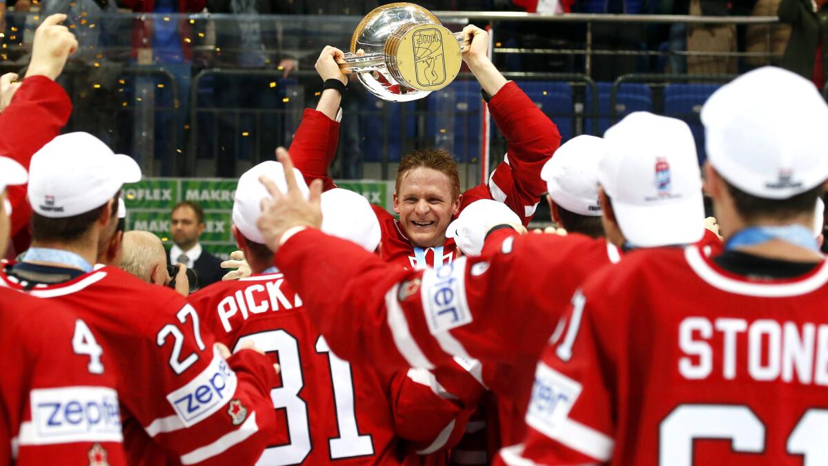 Canada captain Corey Perry lifts the trophy as his teammates celebrate winning the world ice hockey championship on Sunday in Moscow.