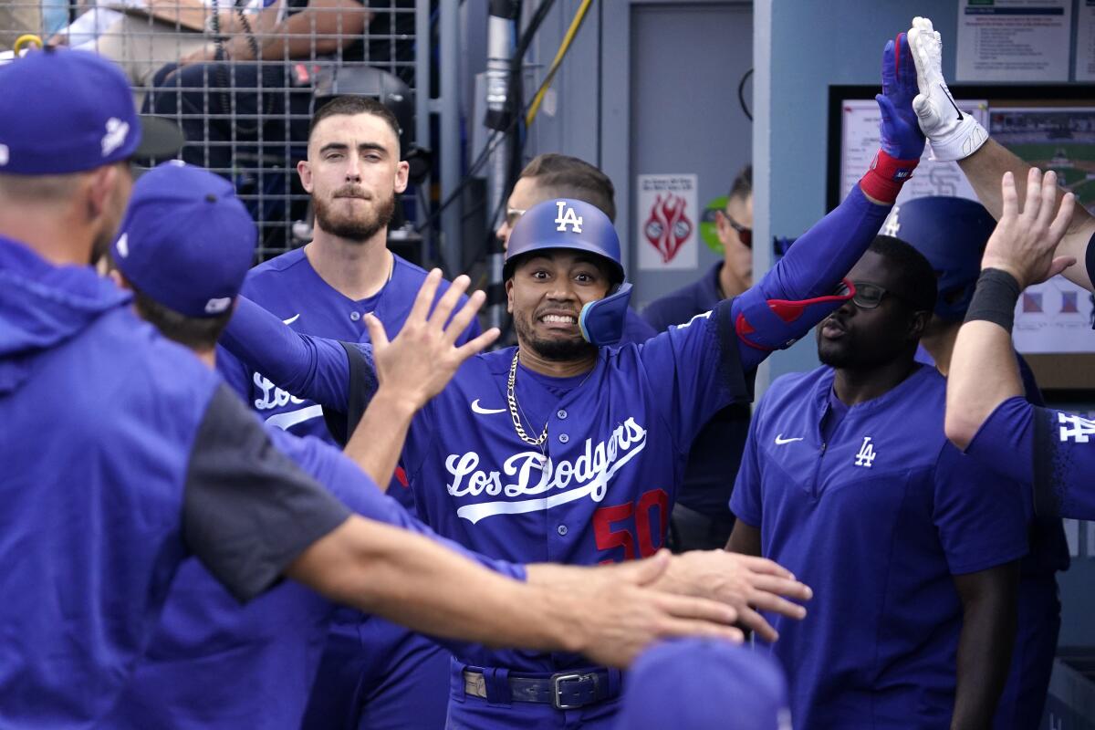 The Dodgers' Mookie Betts is congratulated by teammates in the dugout after hitting a solo homer July 23, 2022.